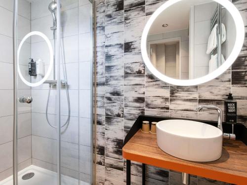 a bathroom with a sink and a shower and a mirror at Ibis Styles Hotel Paris Gare de Lyon Bastille in Paris