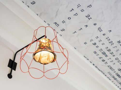 aendant light is hanging from a white table at Ibis Styles Hotel Paris Gare de Lyon Bastille in Paris