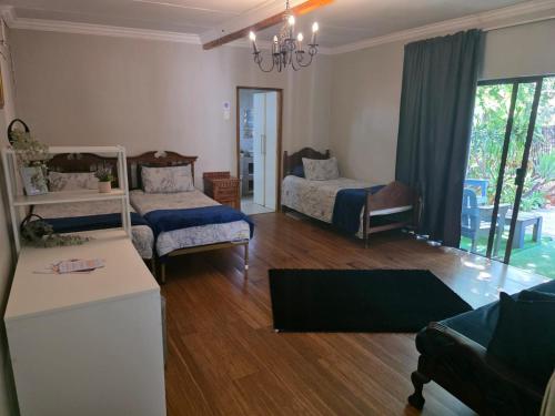 een woonkamer met twee bedden en een bank bij The Pot in Pretoria