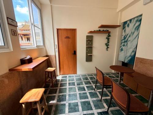 a room with a table and chairs and a door at KM Hostel in Chiayi City