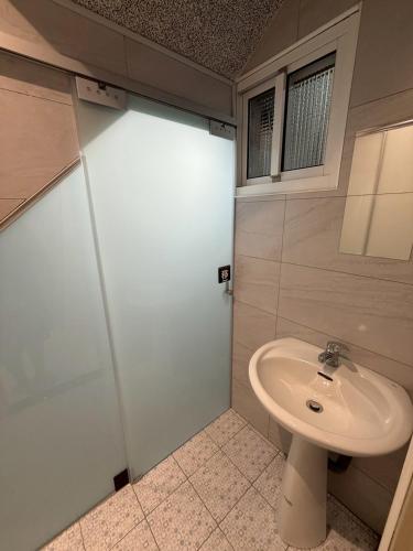 a bathroom with a sink and a shower at KM Hostel in Chiayi City