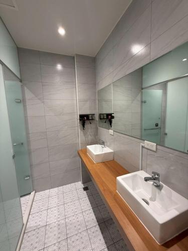 a bathroom with two sinks and a mirror at KM Hostel in Chiayi City
