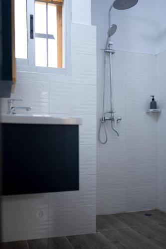 un bagno bianco con lavandino e doccia di Green Haven - Modern Cozy Studio - Fast Wi-Fi - AC - Cocody a Abidjan
