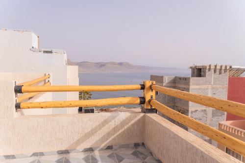 a wooden fence on a building with the ocean in the background at Tifawine Stay Guest House Social Stay and Oceanview Rooms in Imsouane