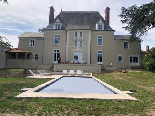 La Chapelle-Basse-MerにあるLa Ferme du domaine de La Mazureの前にプールがある大きな家