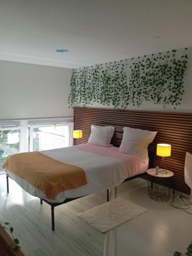 a bedroom with a large bed and a wall with plants at Appartement Chasseneuil Futuroscope in Chasseneuil-du-Poitou