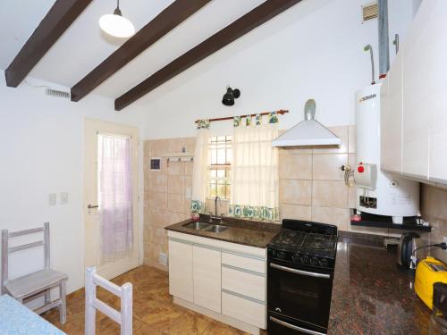 a kitchen with white cabinets and a black stove top oven at La Casa de los Pájaros in Tanti