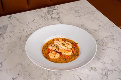 a white bowl of seafood soup on a counter at Toor Hotel Toronto, Part Of Jdv By Hyatt in Toronto