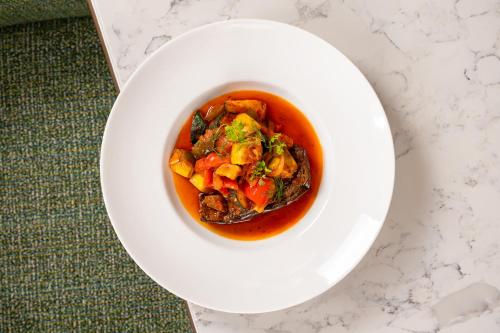 a bowl of soup on a white plate on a table at Toor Hotel Toronto, Part Of Jdv By Hyatt in Toronto