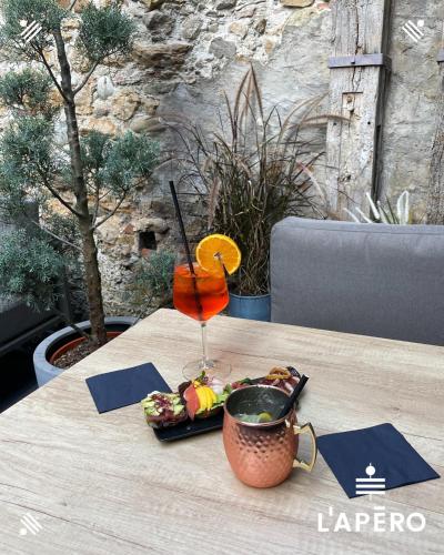 a table with a drink and a plate of food at Hotel du Lac Grandson in Grandson