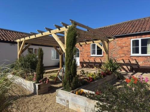 a garden with a wooden pergola in front of a house at The Old Stable in Bridlington