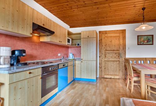 a kitchen with wooden cabinets and a table and a dining room at Huisnhof in Arrach
