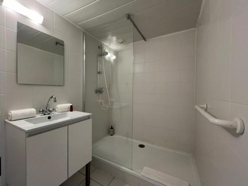 a white bathroom with a sink and a shower at 25m2 Grande Plage, hypercentre, balcon in Biarritz