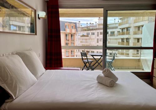 a bedroom with a white bed and a large window at 25m2 Grande Plage, hypercentre, balcon in Biarritz