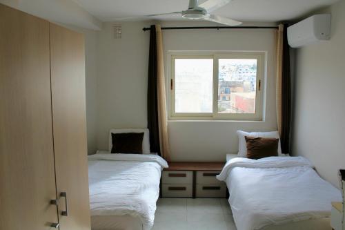 two beds in a room with a window at Twin Room with Private Bathroom - Room 6 in Tal-Għoqod