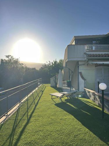 a balcony of a house with a bench on the grass at A Casa Di Mimmo in Fondachello