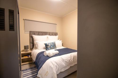 Un dormitorio con una cama grande con una manta azul. en Waterfall Ridge Luxurious Apartment 2 Backup Power, en Midrand