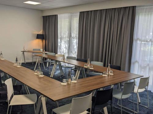 マルセイユにあるMercure Marseille Centre Bompard La Cornicheの長いテーブルと椅子のある会議室