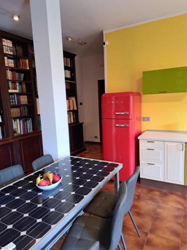 a kitchen with a table and a red refrigerator at Book Paradise in Cremona
