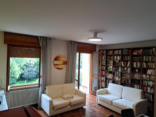a living room with two chairs and bookshelves at Book Paradise in Cremona