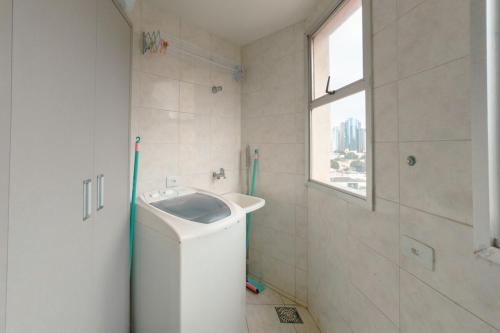 a white bathroom with a sink and a window at Centro de Maringá - Must-see! MH703 in Maringá