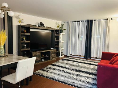 a living room with a television and a red couch at Departamento 3D 2B in Calama