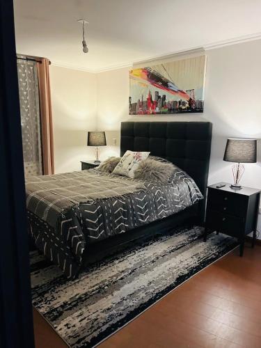 a bedroom with a bed and two lamps on tables at Departamento 3D 2B in Calama