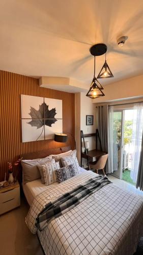 a bedroom with a bed and a chair in it at Stylish and Cozy Earth-tone Studio at Inspiria with Balcony and City-View Free WiFi and Netflix beside Abreeza Mall in Davao City