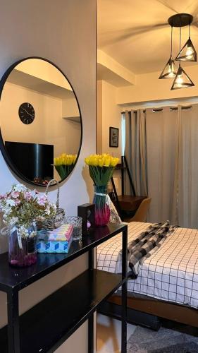 a room with a bed with a mirror and a table at Stylish and Cozy Earth-tone Studio at Inspiria with Balcony and City-View Free WiFi and Netflix beside Abreeza Mall in Davao City