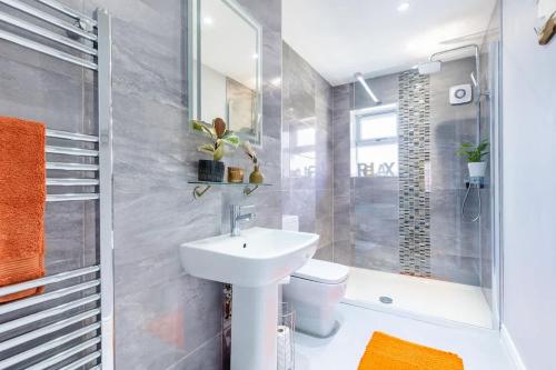 a bathroom with a sink and a toilet and a shower at Townhouse Harbour Retreat in Scarborough