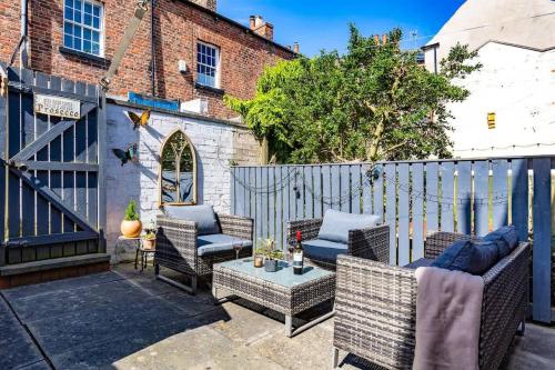 a patio with wicker furniture and a fence at Townhouse Harbour Retreat in Scarborough
