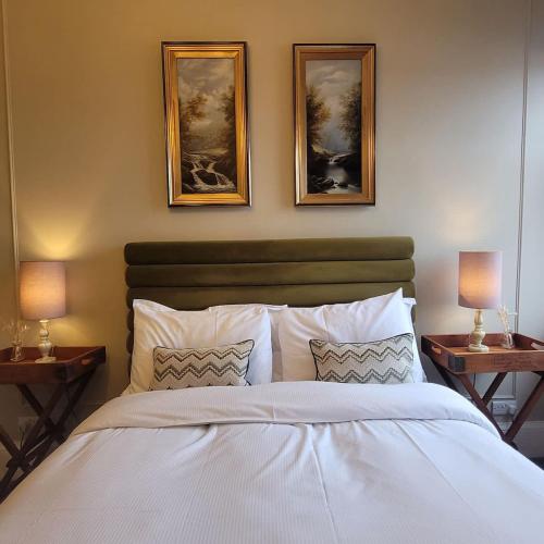 a bedroom with a white bed with two pictures on the wall at Crescent View Central & Quiet Sleeps 4 in Scarborough