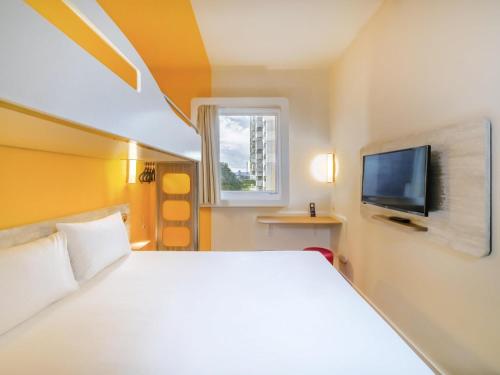 a bedroom with a white bed and a television at ibis budget Sao Caetano in São Caetano do Sul