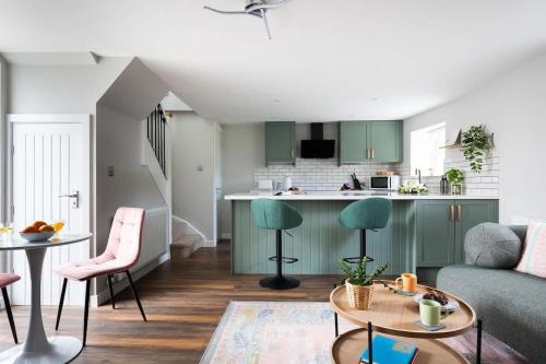 a living room and kitchen with green cabinets at Ivy Mews - Converted Barn in Popular Village in Scarborough