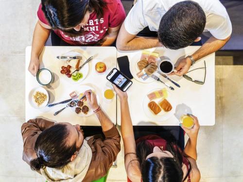 a group of people sitting around a table eating food at ibis budget Sao Caetano in São Caetano do Sul