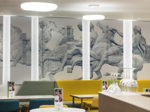 a room with a wall with a mural of statues at ibis Styles Athens Routes in Athens