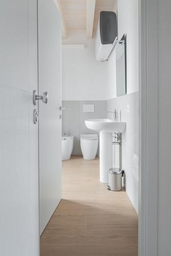 a white bathroom with a sink and a toilet at LaNica Maison in Castelfranco Emilia