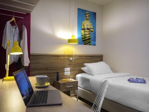 a bedroom with a bed and a laptop on a desk at ibis Styles Athens Routes in Athens