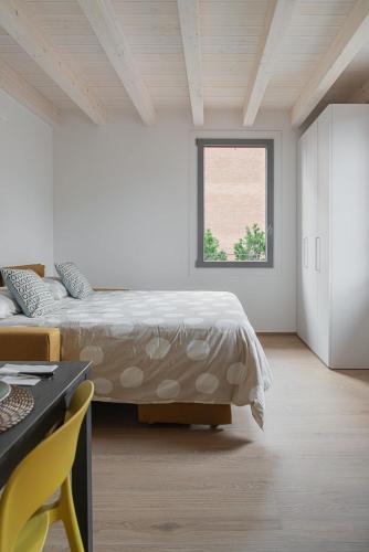 a white bedroom with a bed and a window at LaNica Maison in Castelfranco Emilia