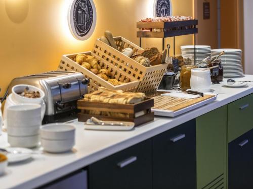 a table with baskets of bread and other food on it at ibis Styles Athens Routes in Athens