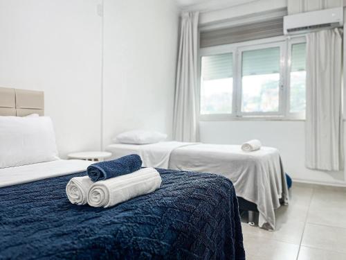 una camera d'albergo con due letti e asciugamani su un letto di Edifício Dom Carlos a Rio de Janeiro
