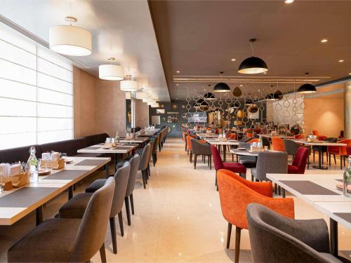 a dining room with tables and chairs and a unintention at Grand Mercure Bengaluru at Gopalan Mall - An Accor Brand in Bengaluru