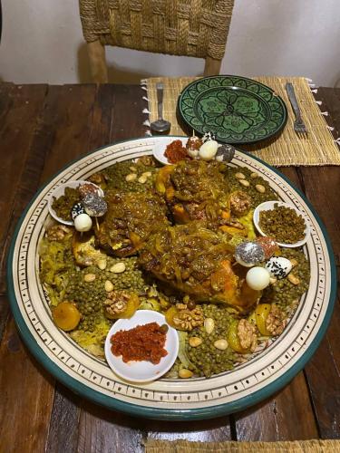 a large plate of food on a wooden table at Bright Wave Surfhouse in Tamraght Ouzdar