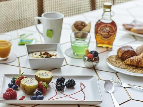 a table topped with plates of food and drinks at Ibis Styles Paris Gennevilliers in Gennevilliers