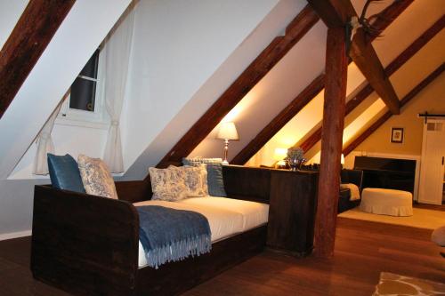 a attic room with a bed and a chair at Burgunderhof - Steiermark in Sankt Anna am Aigen