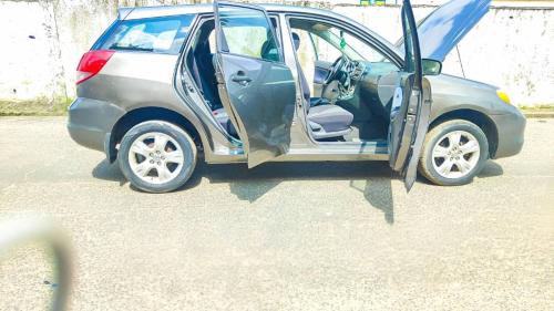a small car with its door open on a street at Bafoussam derrière Stade municipal Bamendzi in Bafoussam