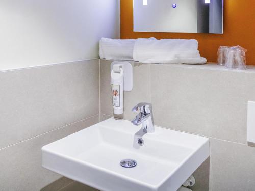 a white sink in a bathroom with towels at ibis budget Huerta De Murcia in Murcia