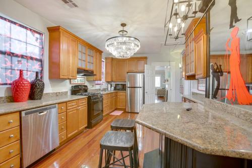 a large kitchen with wooden cabinets and a large island at 2 Mi to Audubon Park Glam NOLA Gem in New Orleans