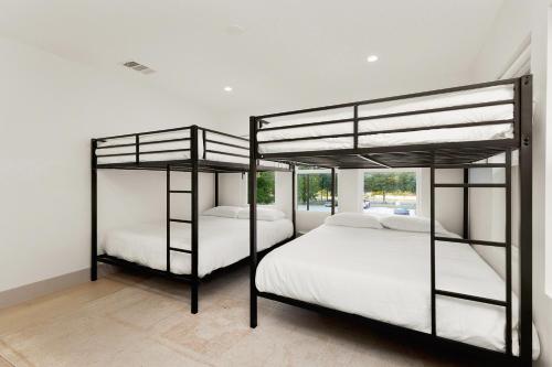 2 letti a castello in una camera con lenzuola bianche di Luxury Downtown Retreat with Pool and Hot Tub, 6Bdr ad Austin
