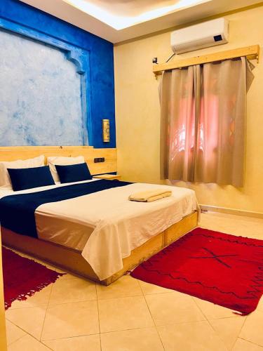 a bedroom with a large bed and a window at Dromadaire Gourmand in Zagora
